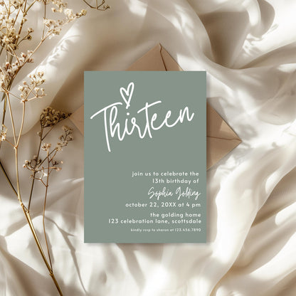 Invitation card for a 13th birthday celebration on a soft fabric background with dried flowers.